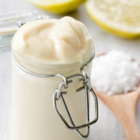 Glasburk med tjock, krämig majonnäs och citron i bakgrunden